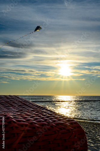 Drachenfliegen im Sonnenuntergang an Strand an der Ostsee