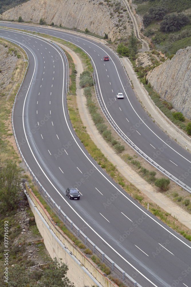 Tramo con curvas de una autopista con algún vehículo Tramo con curvas de una autopista con algún vehículo