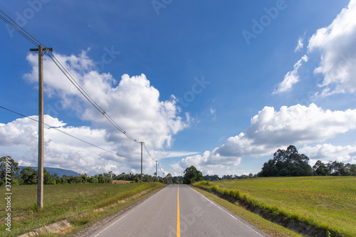 Empty asphalt road with electricity post on countryside