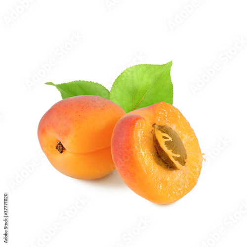 Fresh ripe apricot with leaves, whole fruit and juicy half with pit isolated on white background