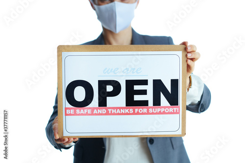 Elegant business woman in grey suit on showing open sign