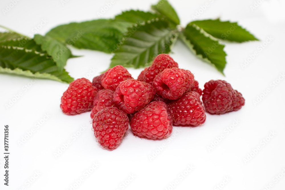 Ripe berries of red raspberries with green leaves on a white background Ripe berries of red raspberries with green leaves on a white background