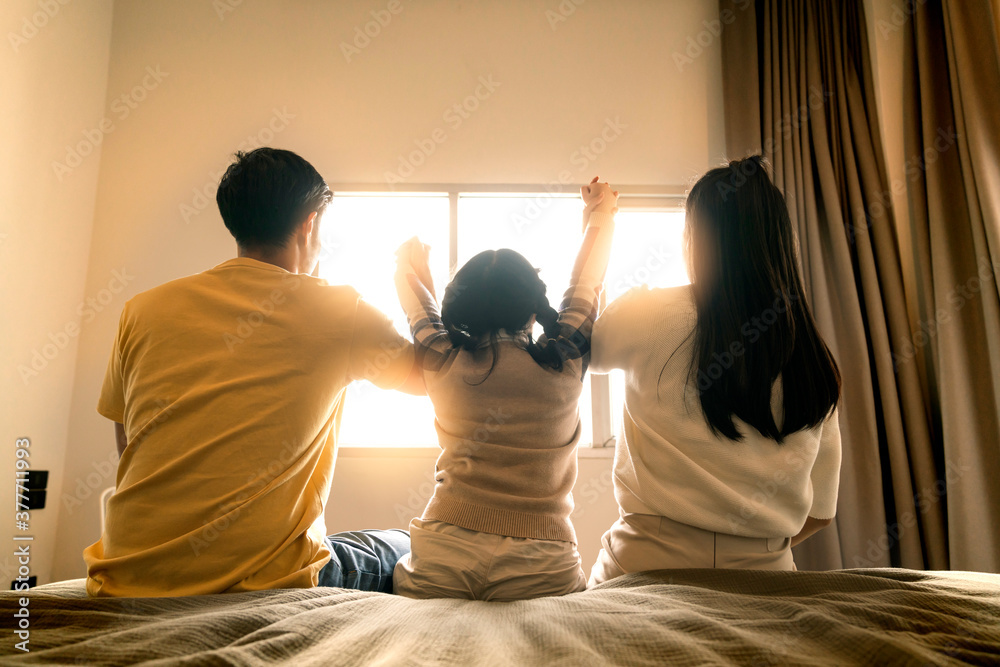 together forever love asian family hand together with morning sunlight flare from window on the bed ,mom dad and daighter hand hold together with care and love in bedroom
