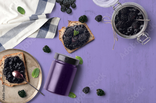 A breakfast scene with blueberry jam on bread. The purple tones with green highlights makes for a cheerful, vibrant background. photo