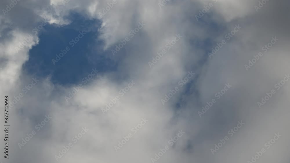 Time lapse of white and grey clouds moving through the sky with one larger area of blue sky.
Time lapse of white and grey clouds moving through the sky with one larger area of blue sky.