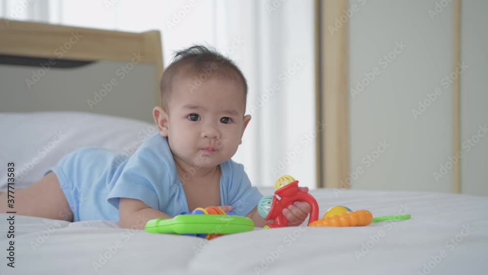 Family concept. The baby is lying alone playing with toys on the bed. 4k Resolution. Family concept. The baby is lying alone playing with toys on the bed. 4k Resolution.