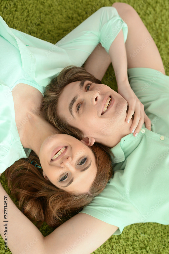 Portrait of happy young couple in love lying on floor at home Portrait of happy young couple in love lying on floor at home