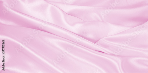 Smooth elegant pink silk or satin texture as wedding background. Luxurious background design