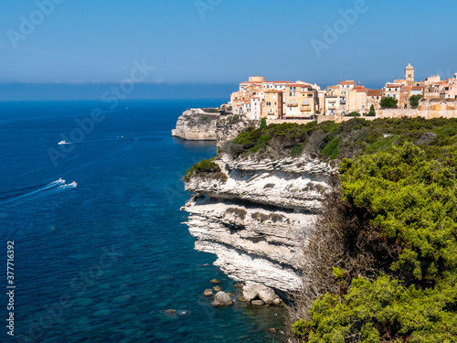 Corsica Bonifacio white cliff with citadel old town facing the Mediterranean Sea during sunny day.