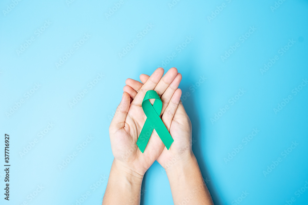 September Ovarian cancer Awareness month, Woman holding teal Ribbon color on blue background for supporting people living, and illness. Healthcare and world cancer day concepts September Ovarian cancer Awareness month, Woman holding teal Ribbon color on blue background for supporting people living, and illness. Healthcare and world cancer day concepts