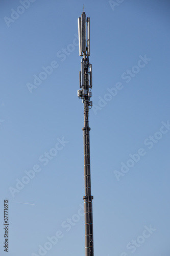 long high cell tower in front of the blue sky