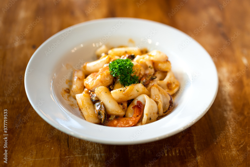 Bulgogi noodle seafood dish, a traditional Korean food menu, which is severed on a wooden table. Selective focus.