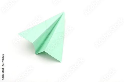 Green paper plane on white