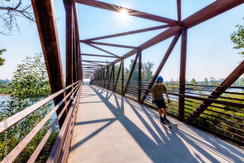 Skate Skier moves across a bridge over the Boise River