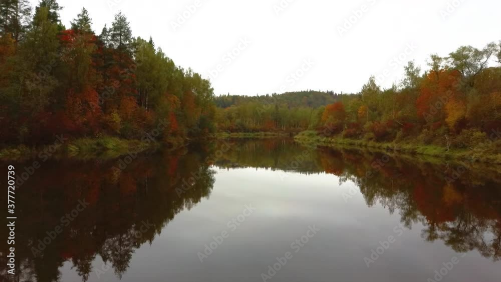 Autumn Landscape View of the Gauja River by Forests Colorful Bright Yellow Orange and Green Trees, Sunny Day. Sigulda, Latvia During Golden Autumn Season in Latvia. Aerial Dron Shoot. Autumn Landscape View of the Gauja River by Forests Colorful Bright Yellow Orange and Green Trees, Sunny Day. Sigulda, Latvia During Golden Autumn Season in Latvia. Aerial Dron Shoot.