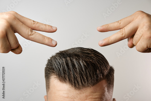Man showing on his perfect haircut after barbershop. Treatment against hair lost and dandruff. 
