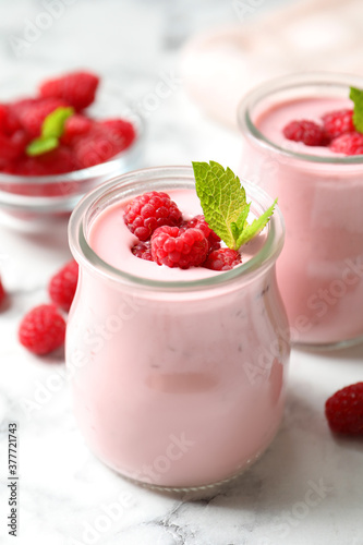Yummy raspberry smoothie on white marble table, closeup