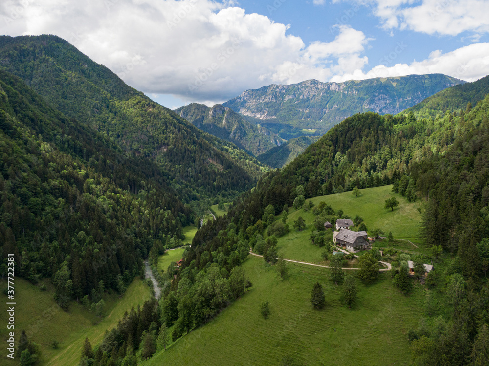 AERIAL: Flying over a small farm atop of a hill in scenic Logarska Valley.