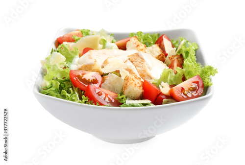 Delicious fresh Caesar salad in bowl on white background