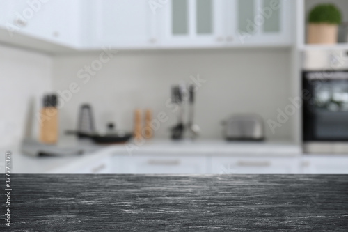 Black wooden table in light kitchen. Space for design