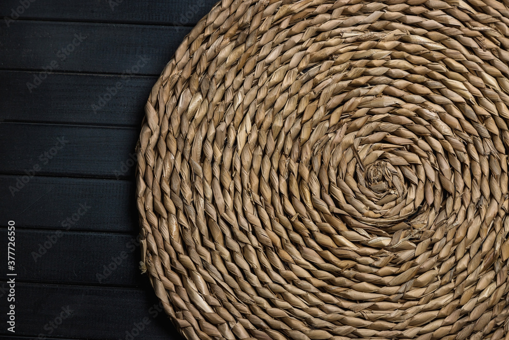 Natural straw table Mat round wicker, Central spiral, on a table made of dark boards