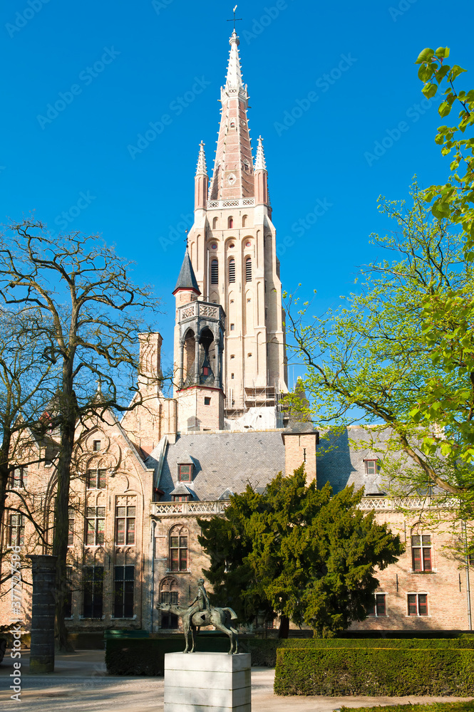 Church of our Lady (Onze-Lieve-Vrouwekerk) and One of the Four Horsemen of the Apocalypse (Bronze Sculpture of Rik Poot), Historic centre of Bruges, Belgium, Unesco World Heritage Site Church of our Lady (Onze-Lieve-Vrouwekerk) and One of the Four Horsemen of the Apocalypse (Bronze Sculpture of Rik Poot), Historic centre of Bruges, Belgium, Unesco World Heritage Site