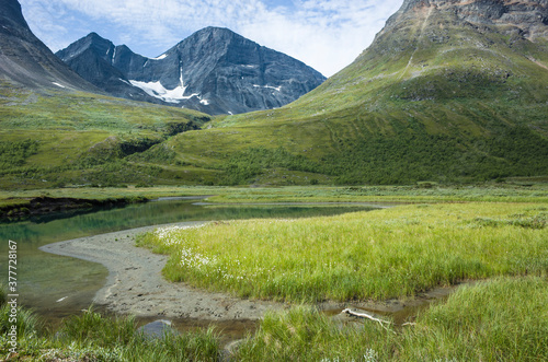 Swedish Lapland landscape. Mountain Passustjakka view from Vistasvagge valley in northern Sweden. Arctic environment of Scandinavia in summer day and calm water of Visstasjohka river photo