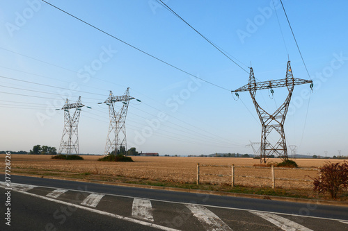 Group of electric pylons, high voltage lines. Overhead cables carrying electricity to cities.
