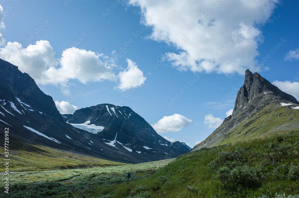 Hiking in picturesque Swedish Lapland landscape. Nallo mountain in northern Sweden. Arctic environment of Scandinavia in summer sunny day with big fluffy clouds Hiking in picturesque Swedish Lapland landscape. Nallo mountain in northern Sweden. Arctic environment of Scandinavia in summer sunny day with big fluffy clouds