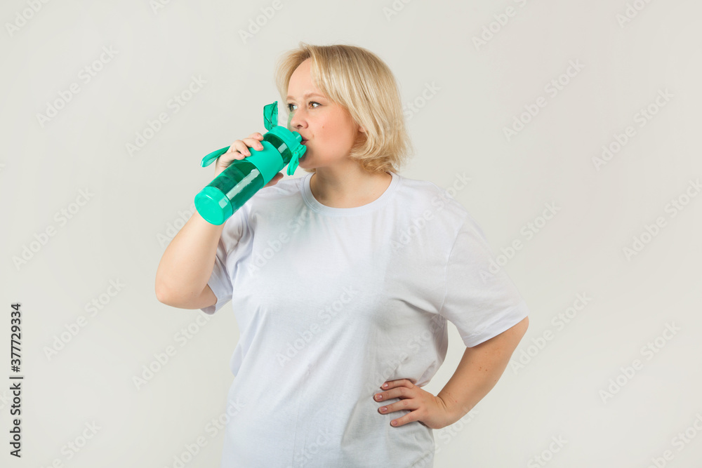 beautiful young plump woman in a white t-shirt on a white background with a shaker beautiful young plump woman in a white t-shirt on a white background with a shaker