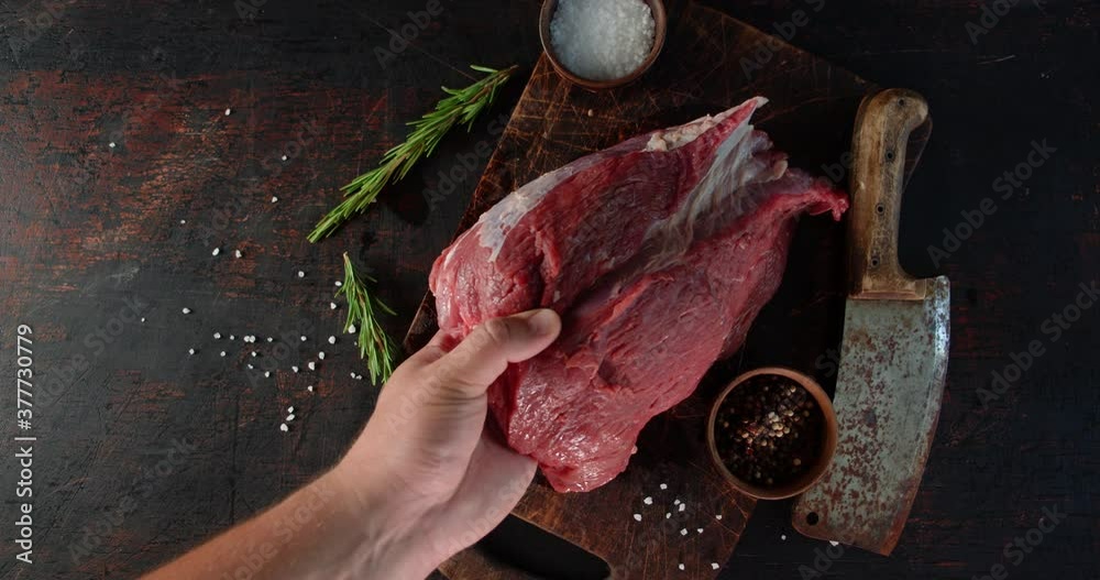 A piece of beef is put on the cutting board.