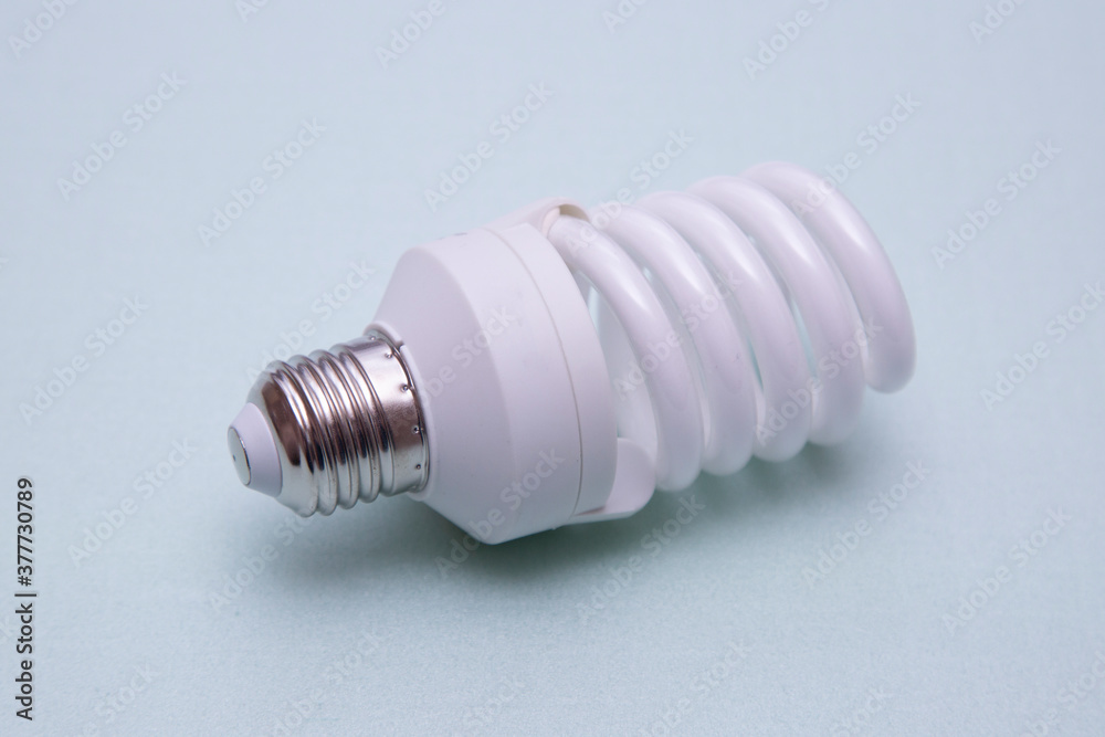 A fluorescent light bulb on a green background. New lightbulb. A fluorescent light bulb on a green background. New lightbulb.