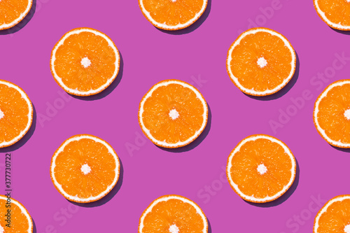 Top view of fresh lemon seamless pattern on pink or fuchsia background. Many sliced yellow lemon seamless texture and lilac background. Fruit minimal concept.