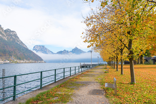 lakeside promenade Unterlangbath, traunsee lake with mountain view and autumnal trees © SusaZoom
