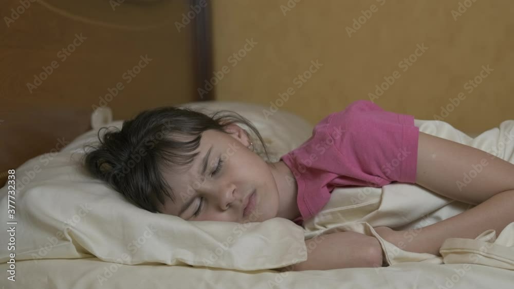 Cover ears with a pillow. An unhappy teen cover her ears with a pillow in the bed in the morning. A concept of loud neighbors. Cover ears with a pillow. An unhappy teen cover her ears with a pillow in the bed in the morning. A concept of loud neighbors.