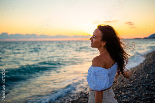 Woman laying on the beach enjoying summer holidays looking at the sea