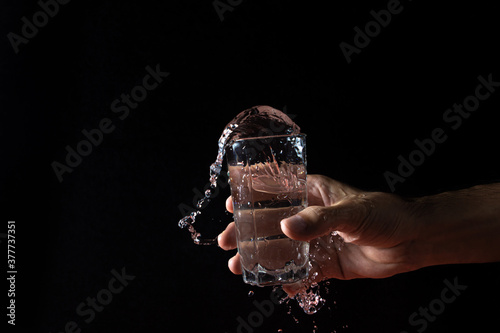 Water on a black background. water is poured out of the glass. Pure water