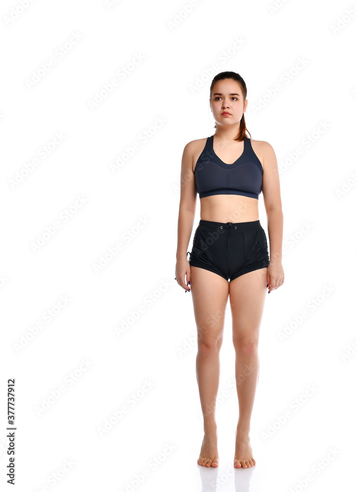 Young beautiful woman standing on her toes against a white background. Young beautiful woman standing on her toes against a white background.