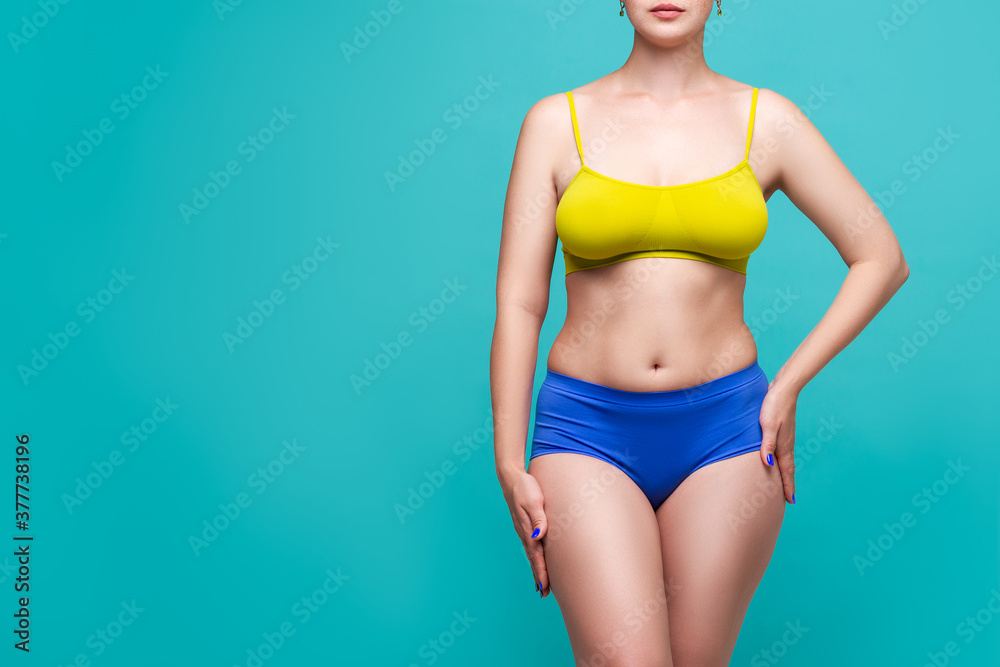 Naklejka premium Beauty woman in multicolored underwear with big natural breasts on blue background