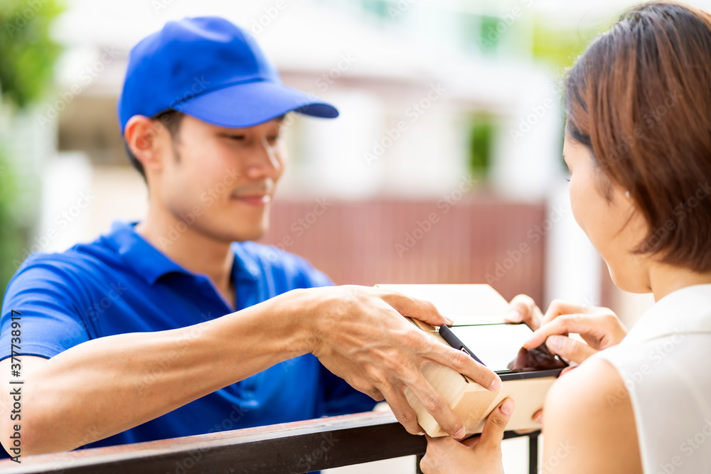 Obraz premium Asian customer woman sign on mobile phone for recieve package delivery.