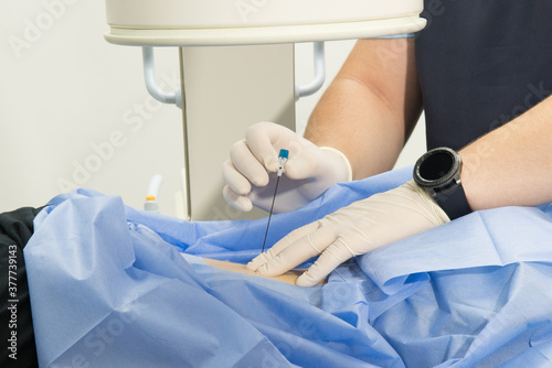 A medical professional gives an injection into the patient's arm . Hands of a medical worker and a syringe close-up. needle, inject medicine