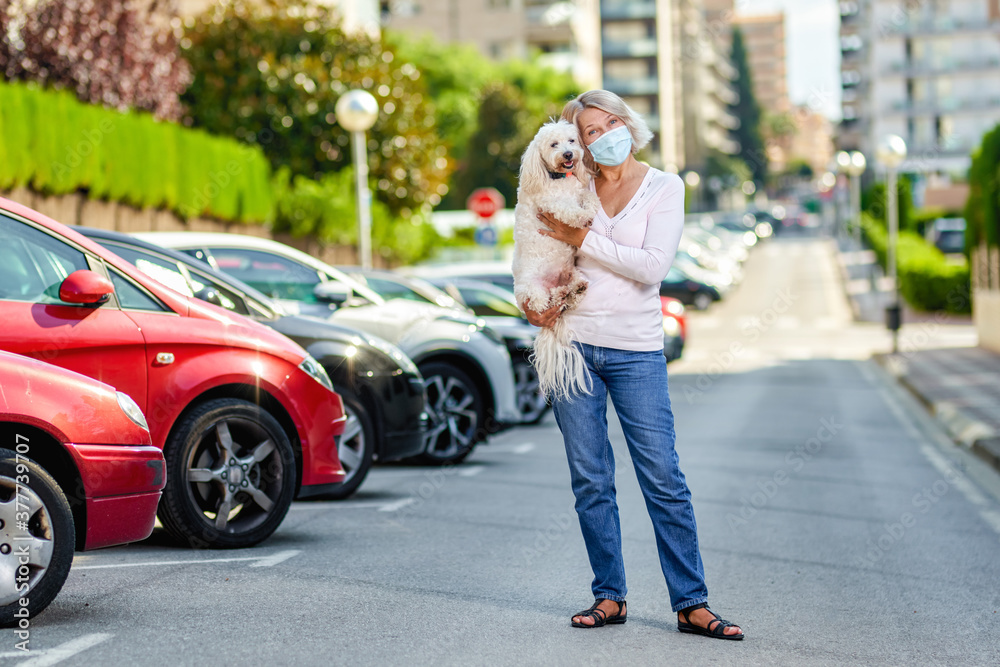 Mature woman walking with a dog outdoors an antivirus mask Mature woman walking with a dog outdoors an antivirus mask