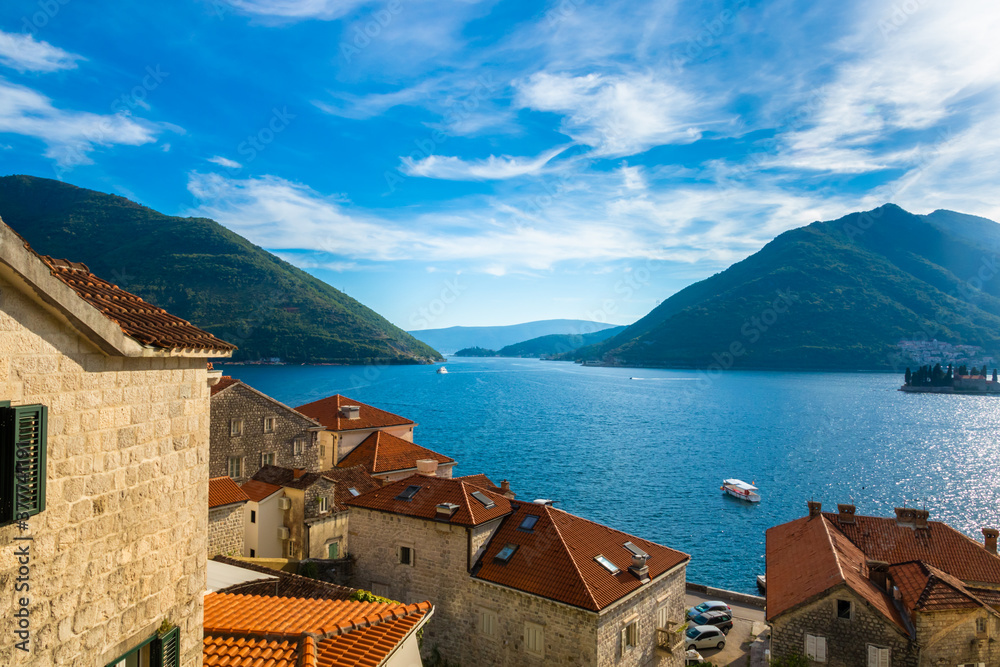 The charming Perast is a European city of Montenegro on the shores of the Adriatic sea near the mountains, beautiful buildings with red tiles postcard