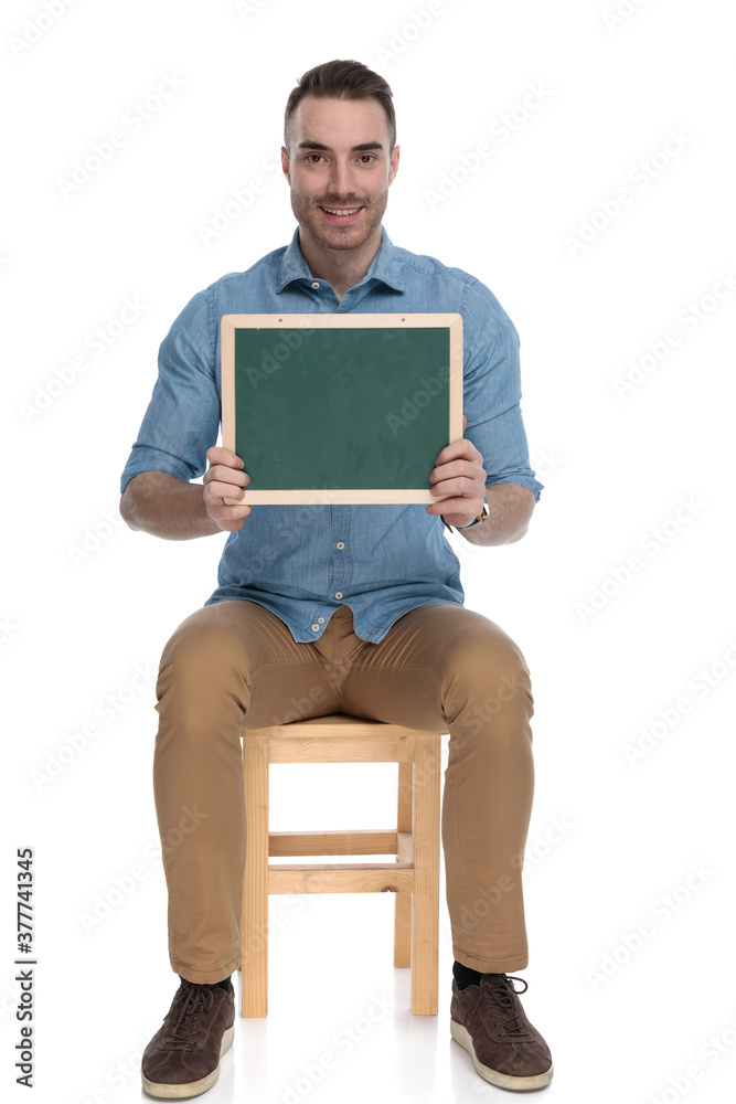 Happy smart casual man smiling and holding blackboard Happy smart casual man smiling and holding blackboard