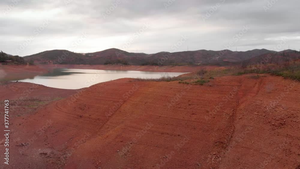 Extremely low water level in a reservoir suffering from a drought as shown by the arid margins. Arade Dam in Algarve, Portugal. Extremely low water level in a reservoir suffering from a drought as shown by the arid margins. Arade Dam in Algarve, Portugal.
