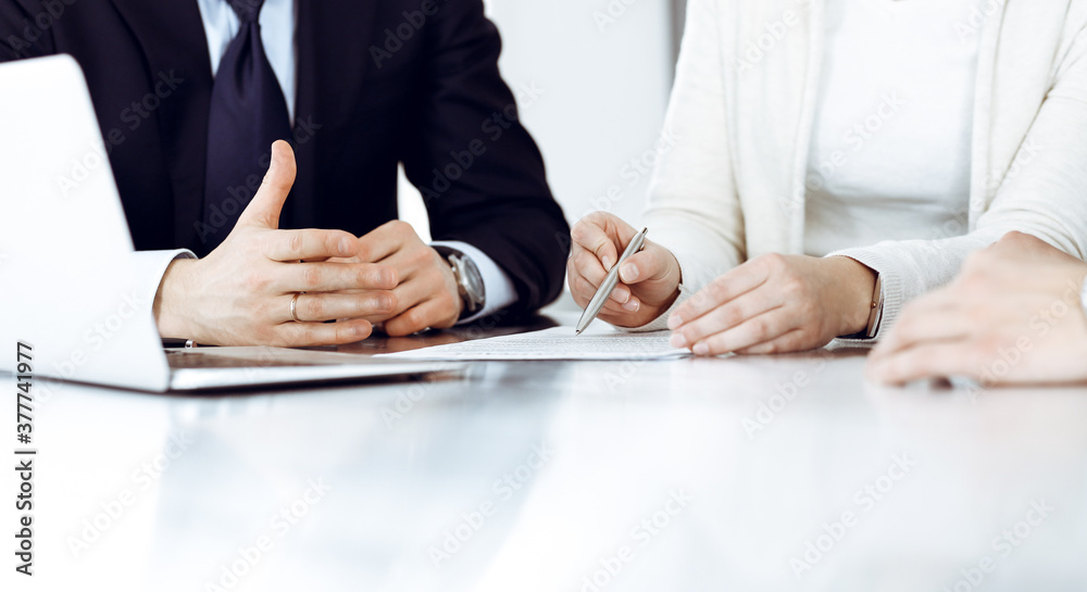 Business people discussing contract working together at meeting in modern office. Unknown businessman and woman with colleagues or lawyers at negotiation Business people discussing contract working together at meeting in modern office. Unknown businessman and woman with colleagues or lawyers at negotiation
