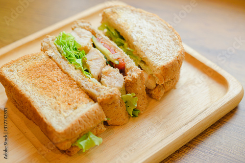 Healthy sandwich with whole grain bread, tomato, lettuce, onion, pepper and chicken.
