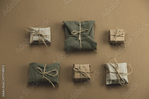 top view flat lay textile and kraft paper gift boxes on a brown background