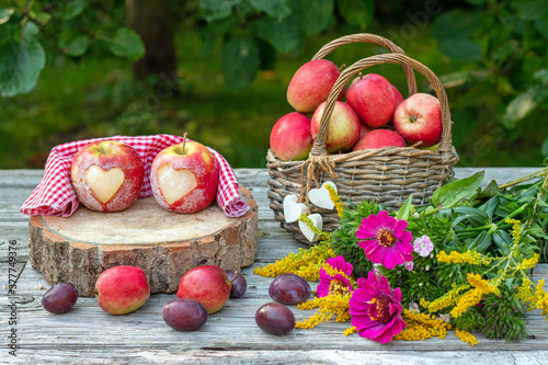 Äpfel mit Herz und Weidenkorb als Dekoration für den Herbst