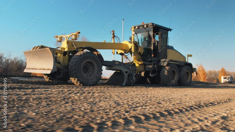 Grader with 3D GPS System. Satellite navigation. A motor grader levels bulk building materials for a new road construction. Road surface repair. Road construction machines. Road works